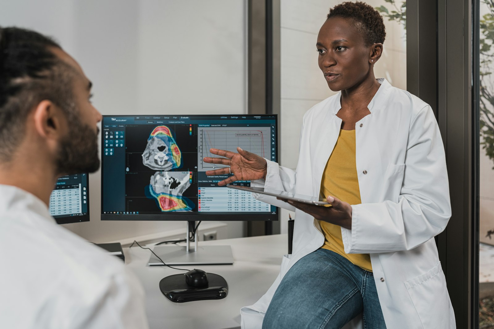 A clinician and an adviser going through a facility's numbers together